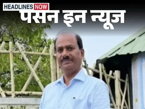 नीली शर्ट पहने एक व्यक्ति आउटडोर में खड़े हुए दिखाई दे रहे हैं