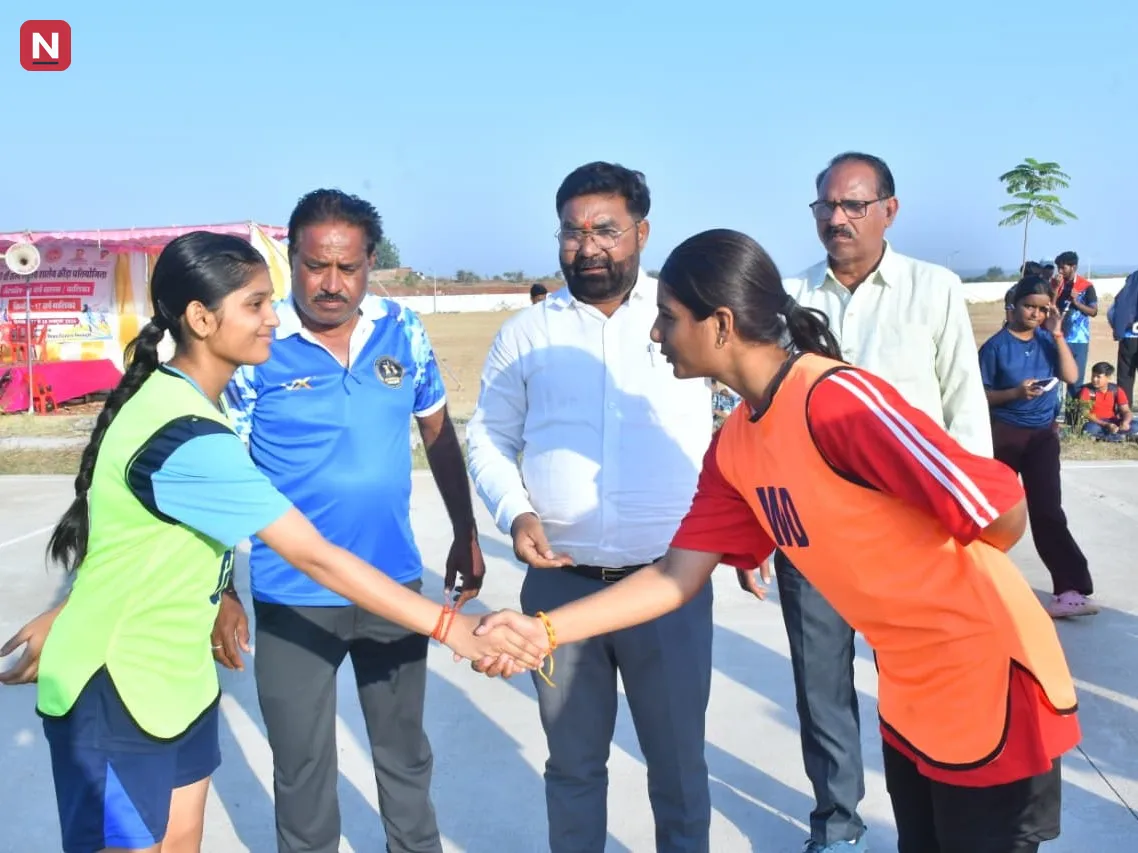 मैदान में खेल प्रतियोगिता के दौरान खिलाड़ी आपस में हाथ मिलाते हुए नजर आ रहे हैं।