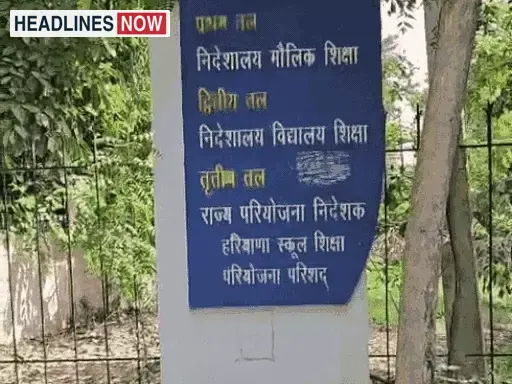 हरियाणा शिक्षा विभाग के कार्यालय का एक साइनबोर्ड और हरे पेड़ दिख रहे हैं